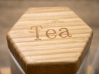 7-piece hexagon ceramic canister set with bamboo display tray – top-down view showing engraved lid labels